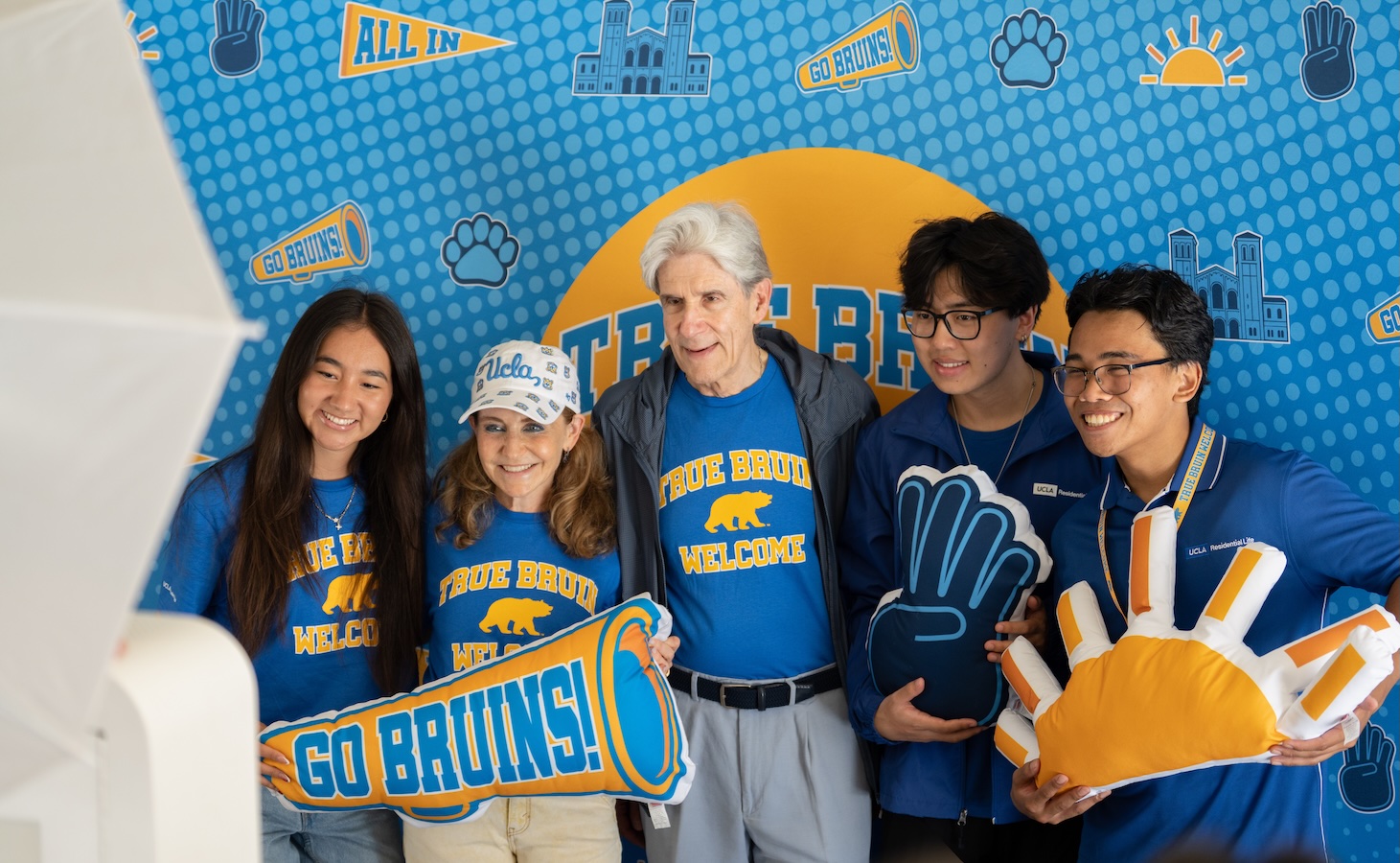 Move-in—Julio Frenk and Felicia Knaul with 3 students in front of True Bruin sign