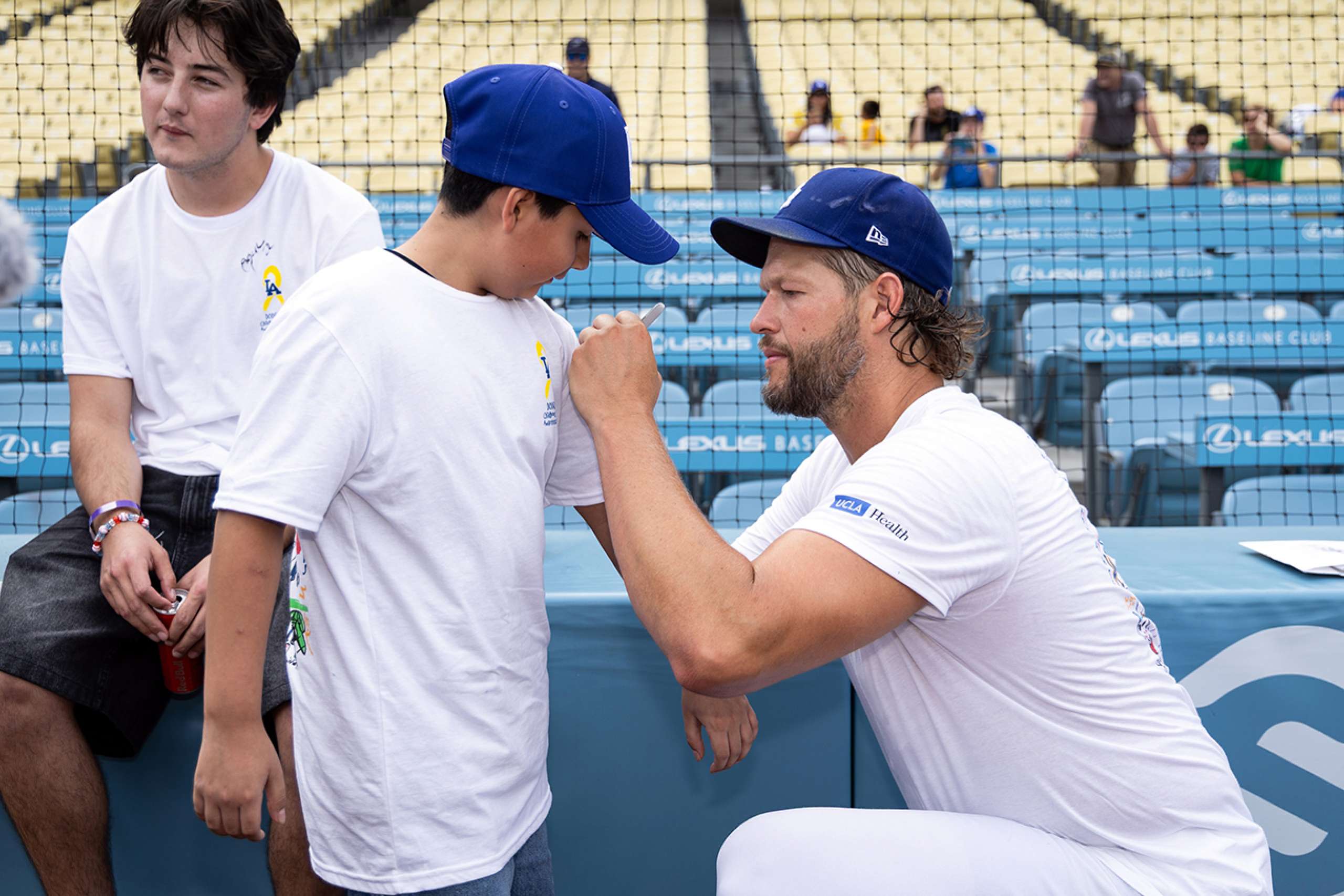 Clayton Kershaw signs an autograph for Isaiah Carino.