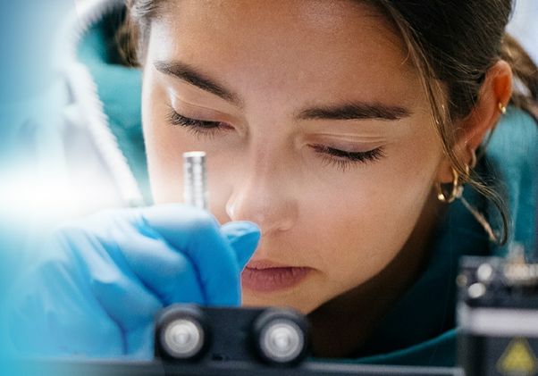 ResearchPowersProgress-Close-up of researcher bent over laboratory equipment