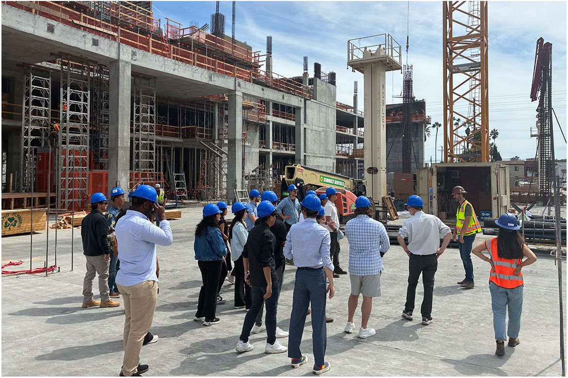 A group of people in blue hard hats at a construction site
