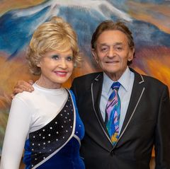 Charlotte Ginsburg, left, in white, blue and sequined outfit stands next to Allen Ginsburg, in black jacket and colorful tie