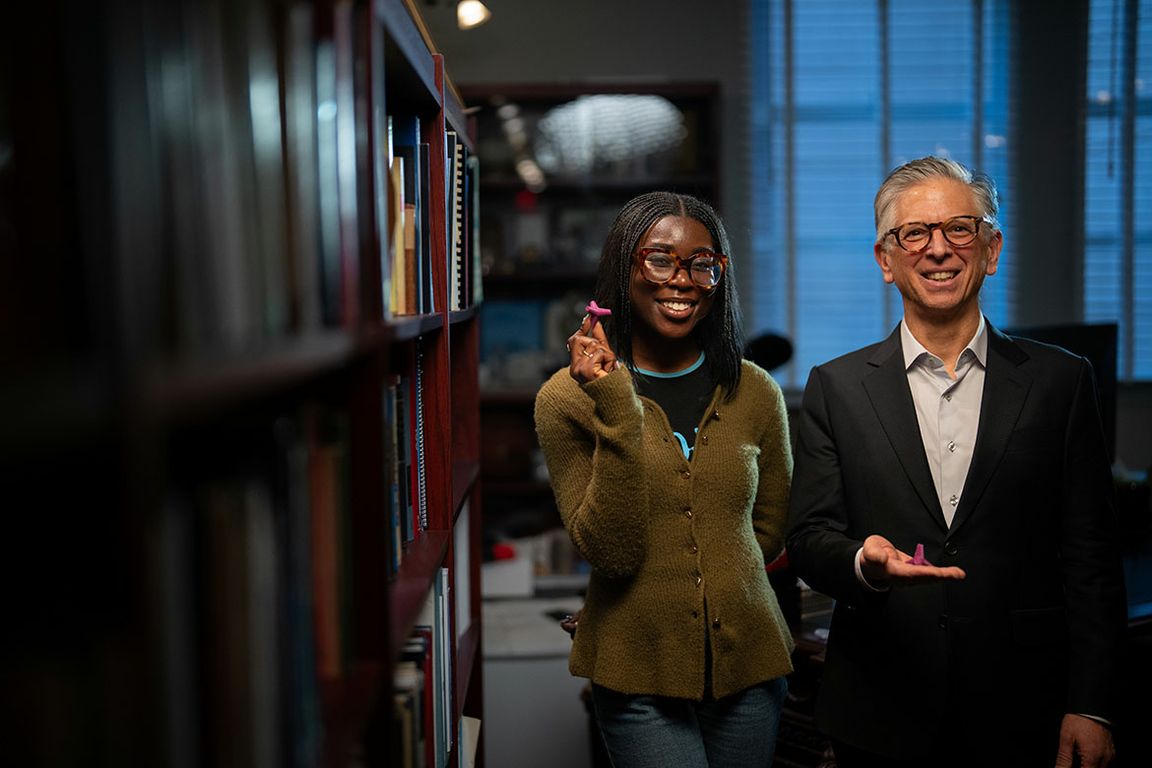 AJ Addae, UCLA chemical biology doctoral candidate, and Paul S. Weiss, UC Presidential Chair and distinguished professor, standing together among library bookshelves.