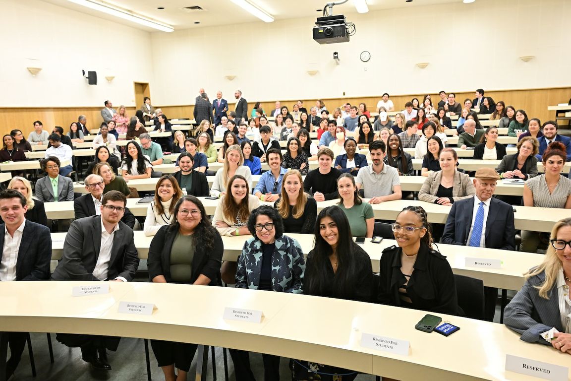 Supreme Court Justice Sonia Sotomayor, front row center in a light-and-dark-blue coat, poses with a large audience of students and guests in a UCLA School of Law lecture hall.