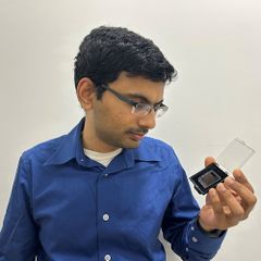 Pradip Gatkine examining a small optical component.