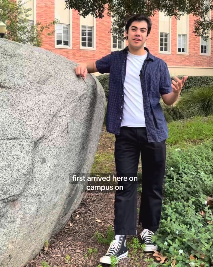 Robert Gurval standing beside Founder's Rock on the UCLA campus.