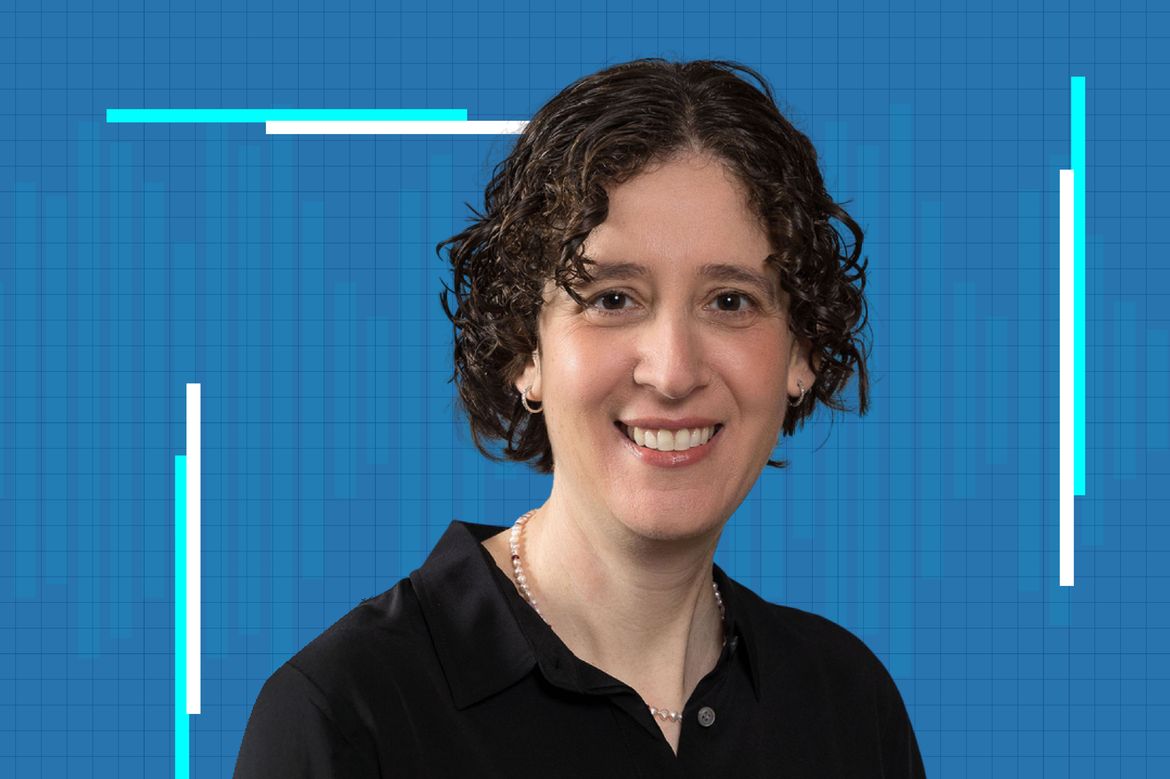 Elissa Hallam smiles in a portrait photo, wearing a black polo shirt and pearl necklace against a bright blue graphic background.