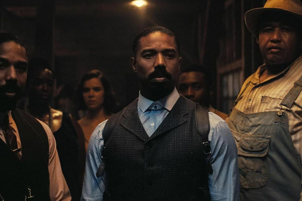Actor Michael B. Jordan stands in period costume in a still from the 2025 horror-thriller musical "Sinners," distributed by Warner Bros.