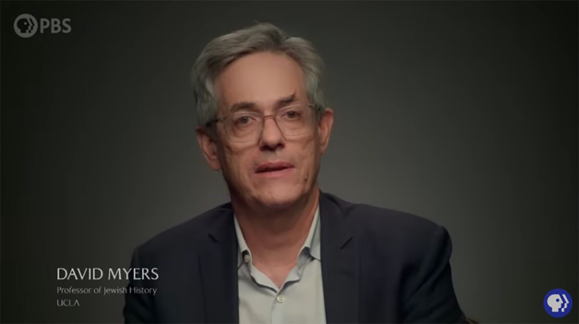 A screenshot from a PBS program shows David Myers, professor of Jewish History at UCLA, speaking on camera against a dark background.