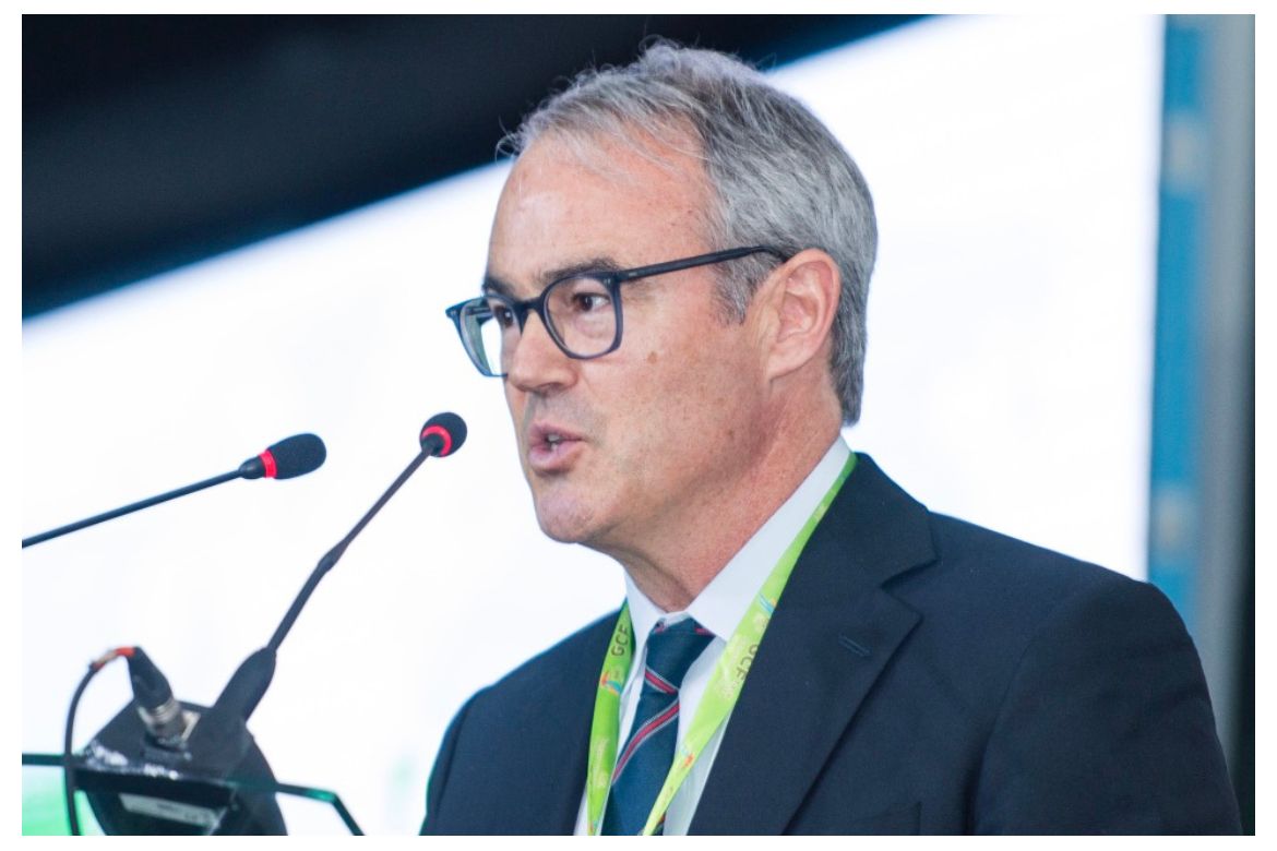  William Boyd, faculty co-director of the UCLA Emmett Institute on Climate Change and the Environment, speaks at a podium with microphones during a conference.