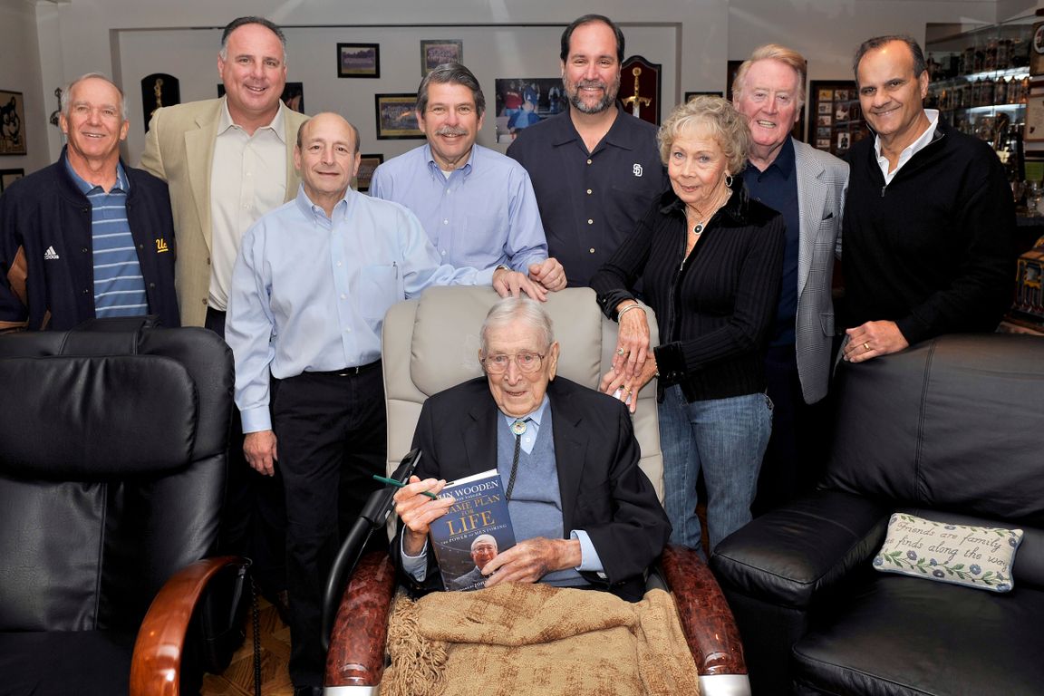 From left, Gary Adams, Mike Scioscia, Angelo Mazzone, Zev Yaroslavsky, Jeff Moorad, Nan Wooden, Vin Scully, and Joe Torre stand behind legendary UCLA basketball coach John Wooden. From left, Gary Adams, Mike Scioscia, Angelo Mazzone, Zev Yaroslavsky, Jeff Moorad, Nan Wooden, Vin Scully, and Joe Torre stand behind legendary UCLA basketball coach John Wooden, who is seated and holding his book "Game Plan for Life."