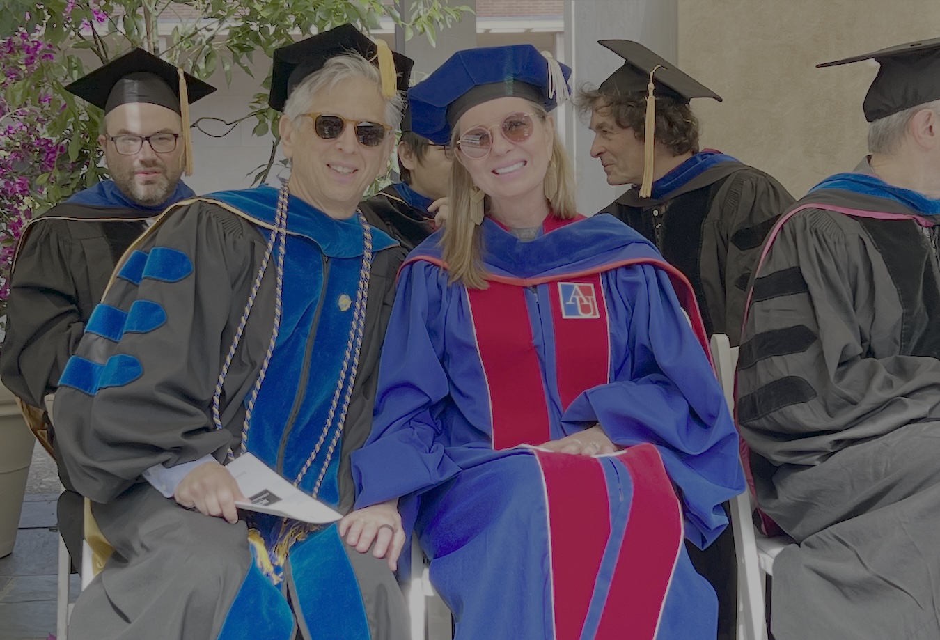Anne Andrews (left) and Paul Weiss sit toreceiveher in academic regalia. 