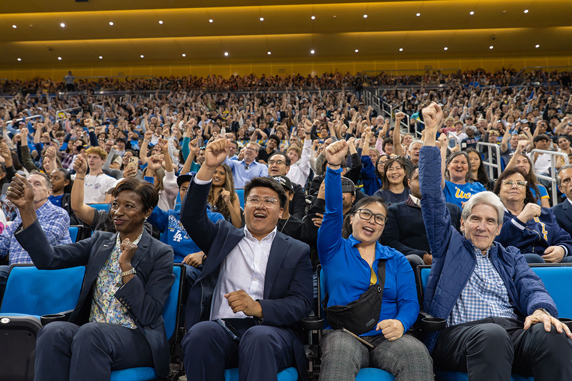 Chancellor Julio Frenk cheers alongside the audience in Pauley Pavilion at the UCLA Bruin Day event.
