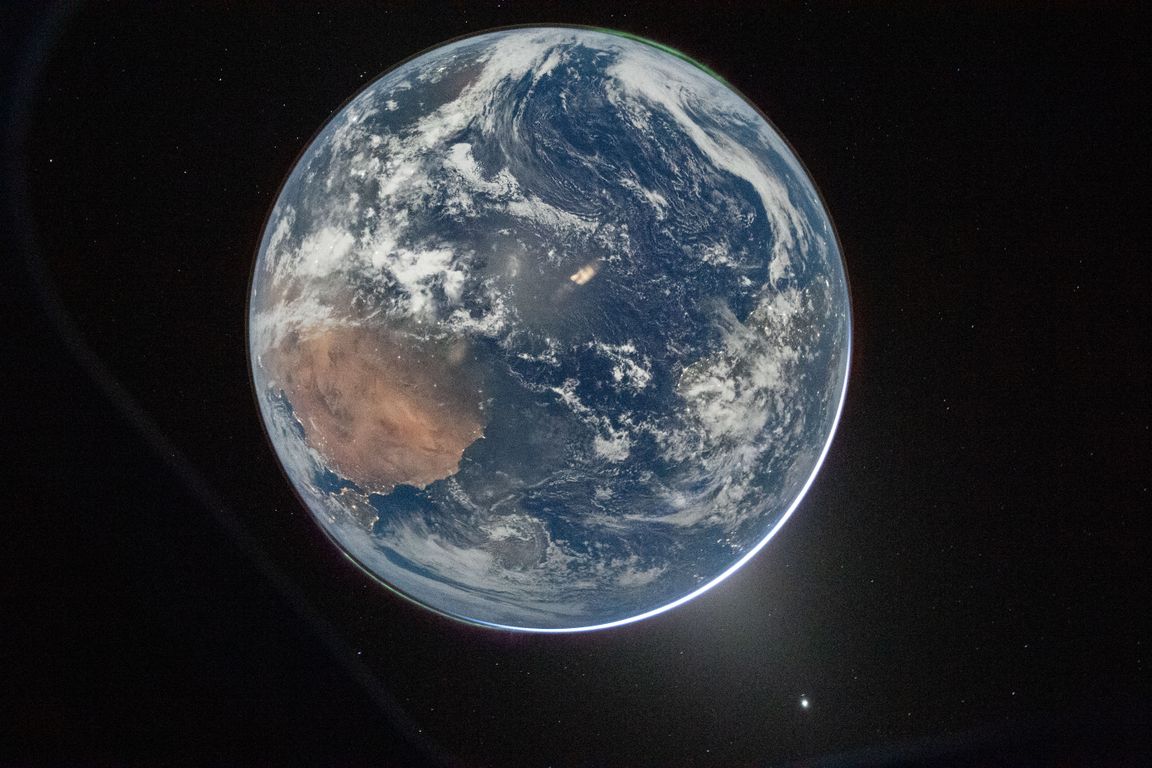 A view of Earth from space captured during the Artemis II mission, showing swirling cloud formations over blue oceans and the Australian continent against a black background.