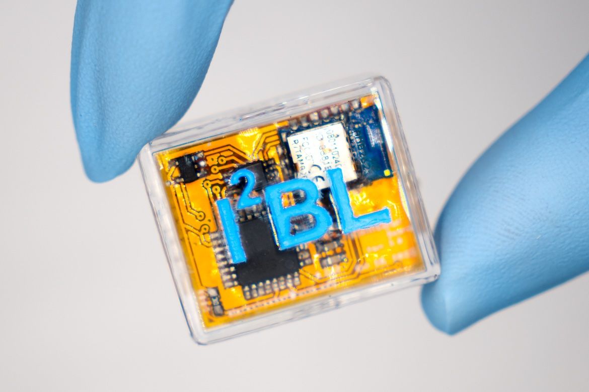 Square microneedle sensor begin held by hand wearing blue Latex gloves