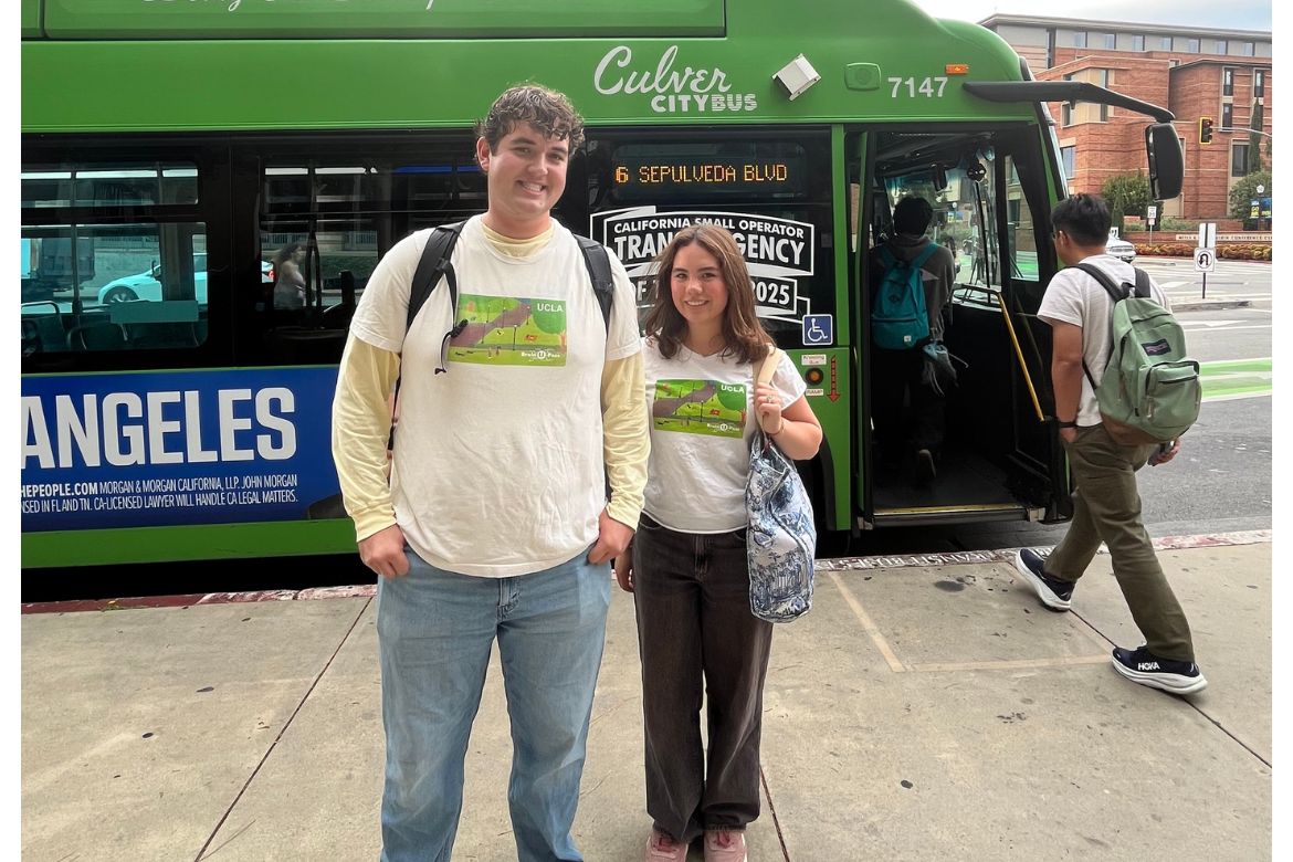 Undergraduates Michael Griffin and Isabella Zirn wear matching white UCLA Bruin U-Pass T-shirts standing in front of lime green Culver CityBus