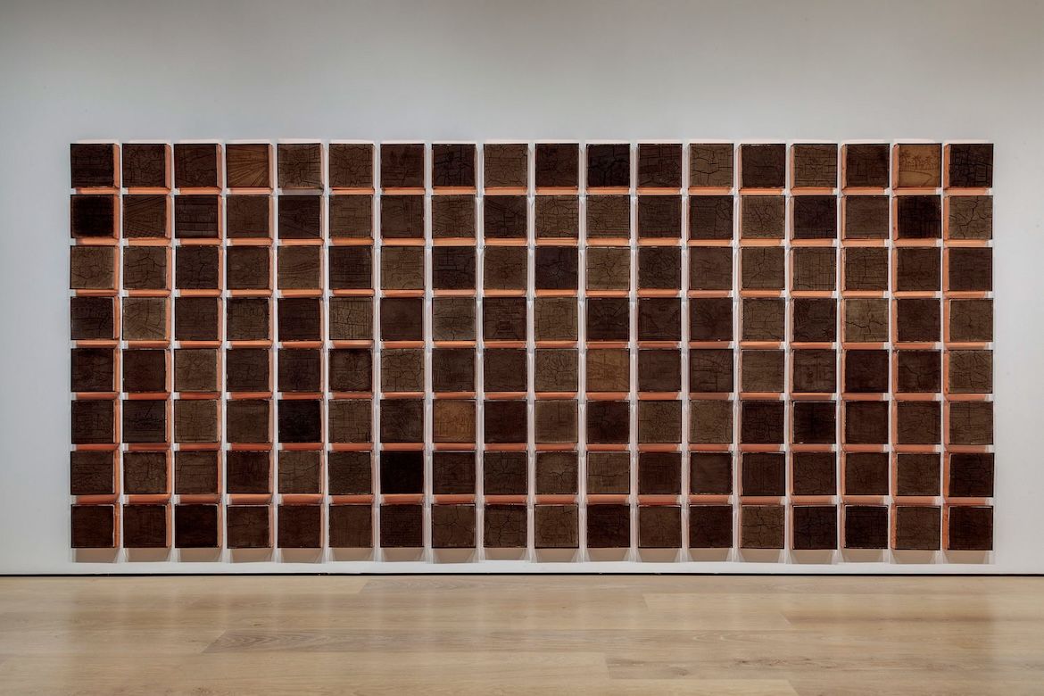 Wall art installation composed of 144 square tiles made from soil and other materials from Los Angeles neighborhoods