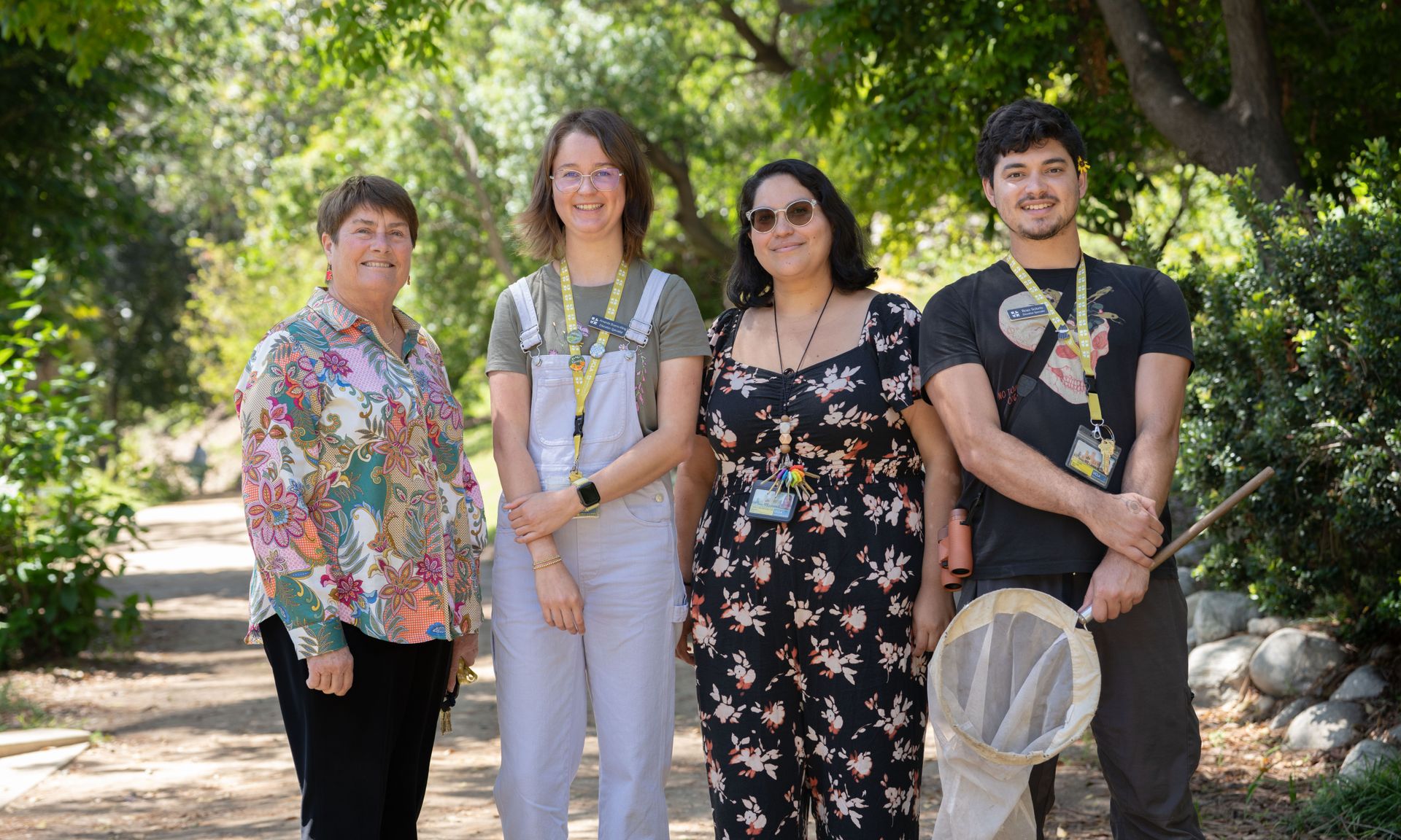 From left, Victoria Sork, Amanda Bueno-Kling, Chantal Ochoa-Clark and Boaz Solorio stand together on a garden path surrounded by trees.