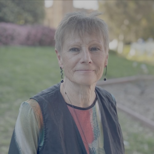 Close-up of Ursula Heise, with short gray hair and dark eyes, photographed outdoors