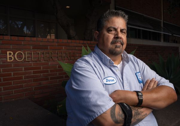 UCLA senior custodian Daniel Estrada stands outside Boelter Hall, where he helps maintain classrooms and engineering spaces after hours for students, faculty and staff.