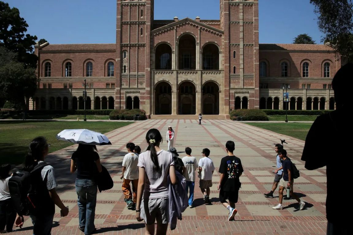 Students walk across UCLA’s Royce Quad toward Royce Hall on a sunny day, with the brick Romanesque building rising in the background.