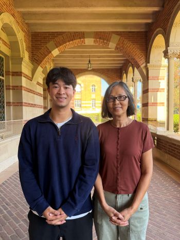 Aiden Le stands next to Thu-Huong Nguyen-Vo under archway