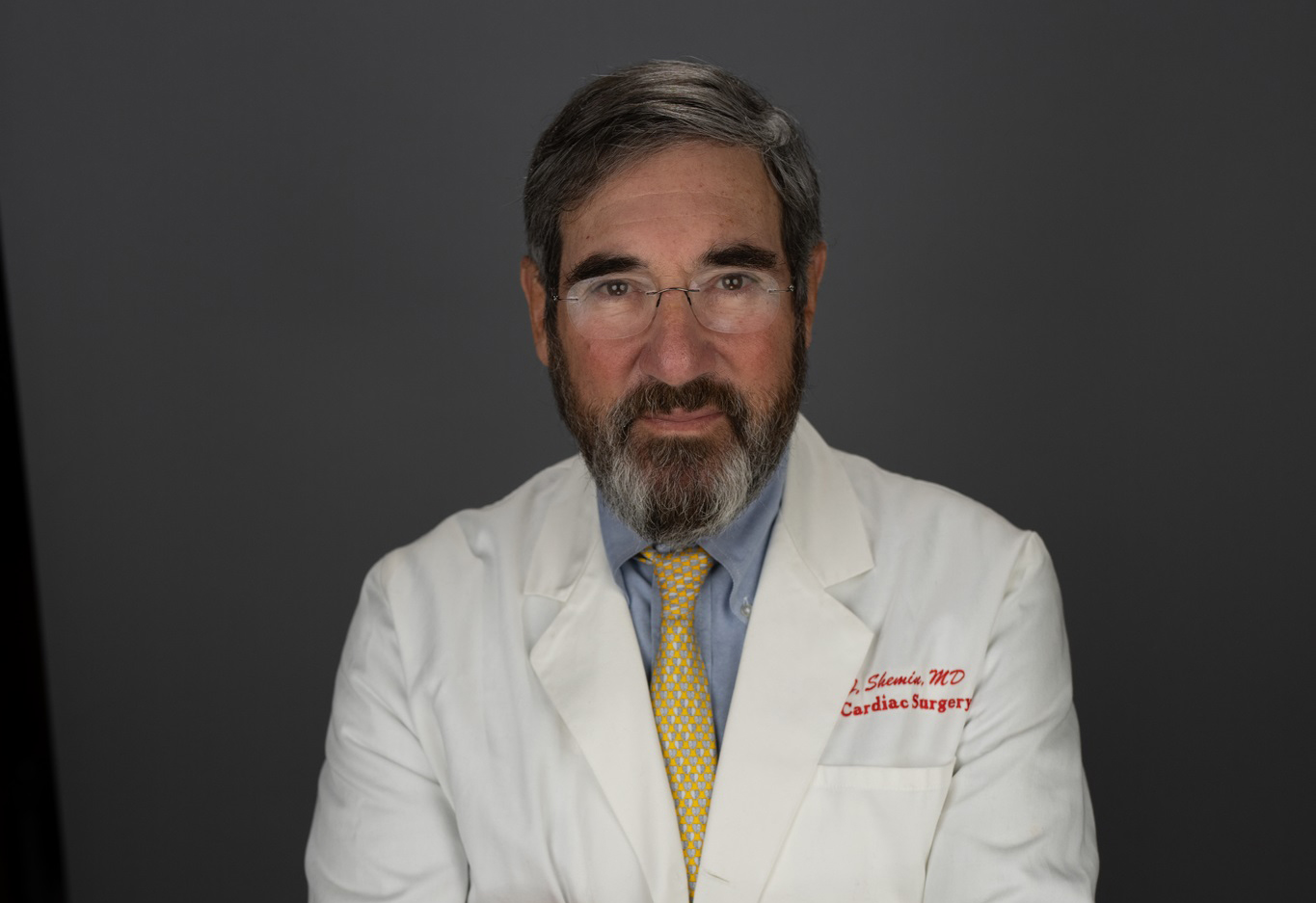 Midrange shot of Richard Shemin in white coat, blue button-down and yellow tie
