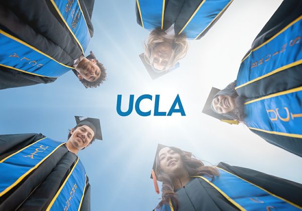 Five graduates in black caps and gowns with blue-and-gold stoles form a circle, viewed from below against a bright sky, surrounding the centered UCLA logo in a celebratory commencement scene.