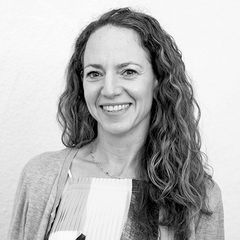 Black-and-white headshot of Brooke Porter Katz wearing a light cardigan over a patterned top, facing the camera against a plain background.