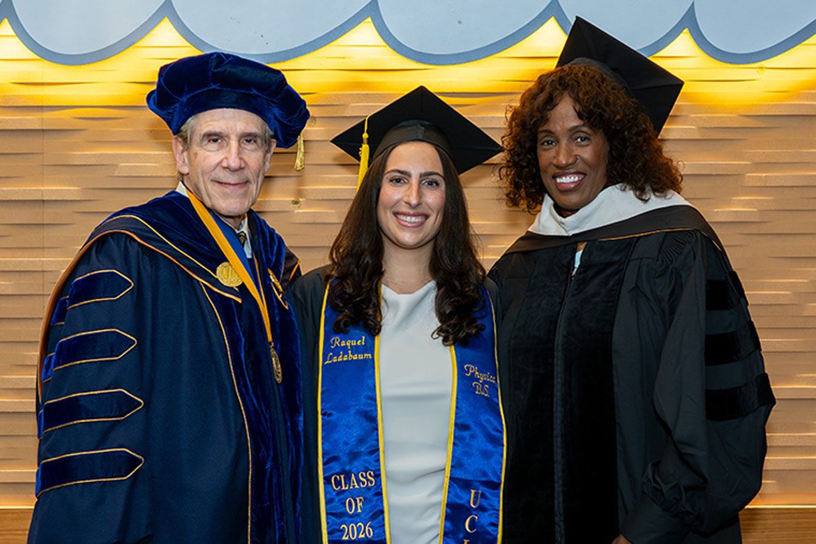Chancellor Julio Frenk, in blue and gold academic regalia, stands with student speaker Raquel Ladabaum, wearing a graduation cap, and keynote speaker Jackie Joyner-Kersee, in a black academic gown and cap.