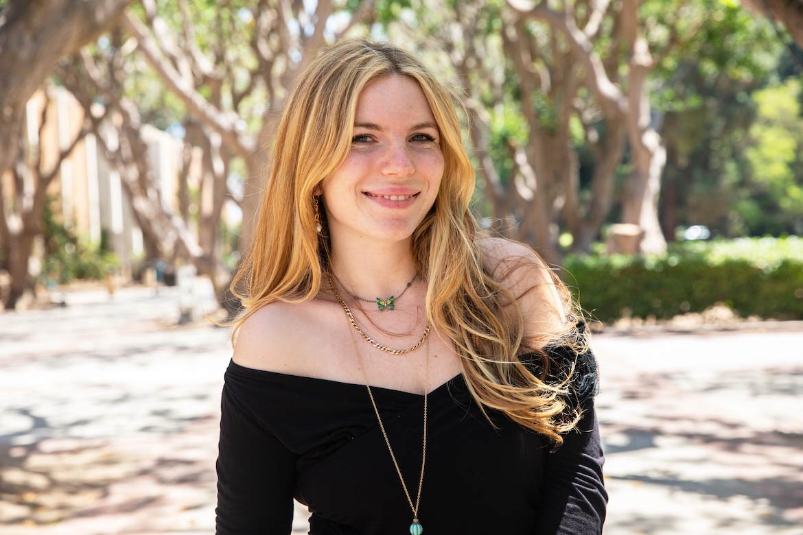 Head-and-shoulders shot of Sarah Lustgarten in shoulderless black top, smiling at camera
