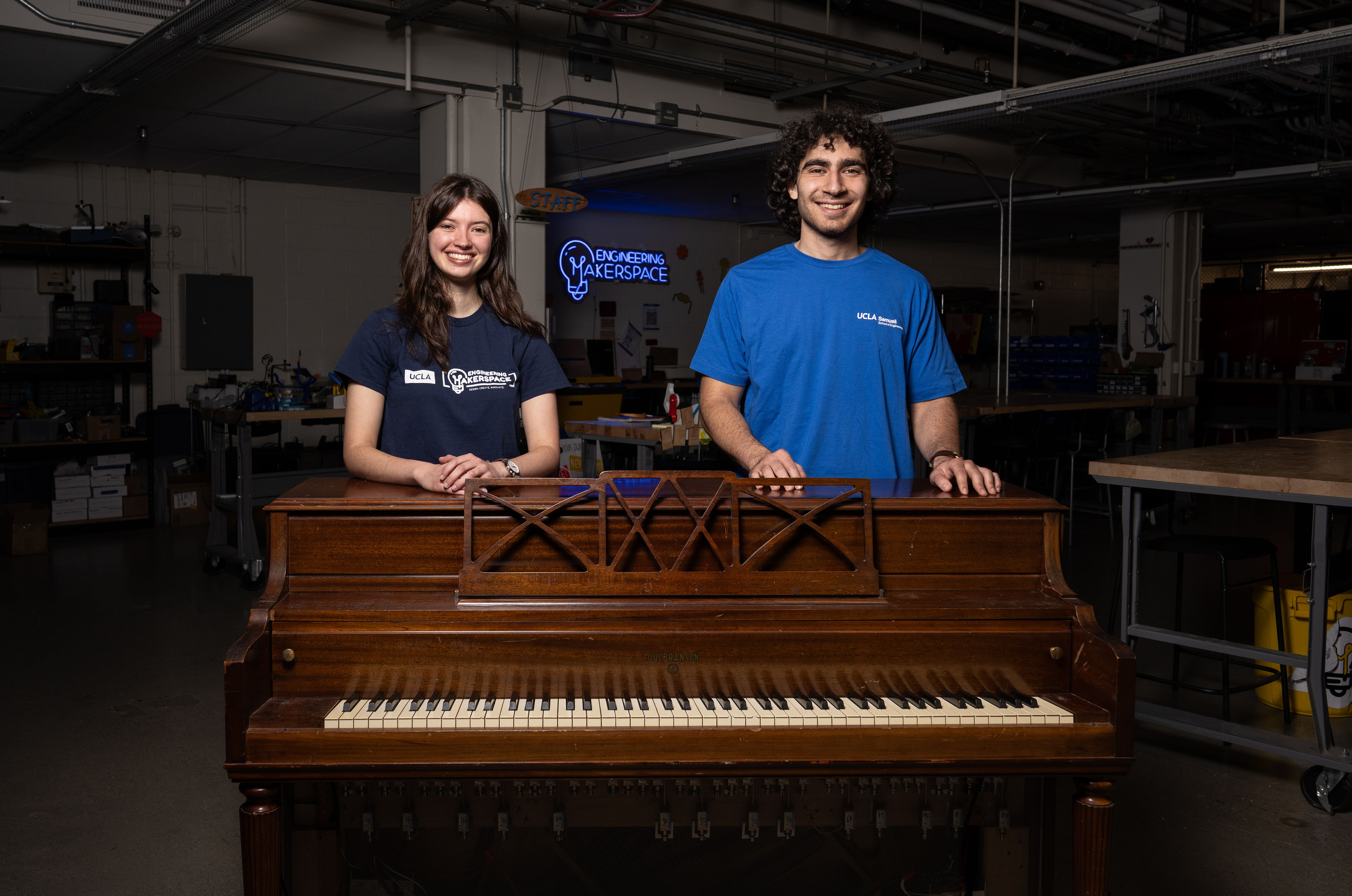 Karina Bender, left, and George Grigoryan stand behind a wooden player piano