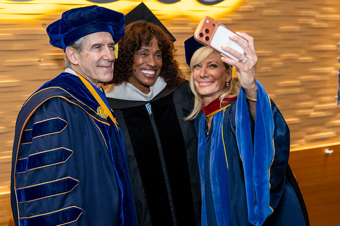 Chancellor Julio Frenk, Jackie Joyner-Kersee, and UC Regent Janet Reilly pose for a selfie at UCLA's 2026 commencement.