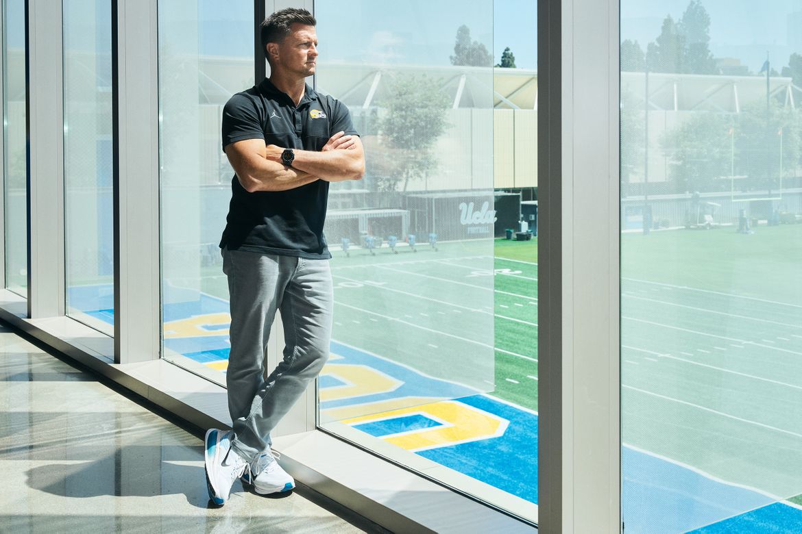 Coach Bob Chesney staring out of the window overlooking UCLA football's practice field