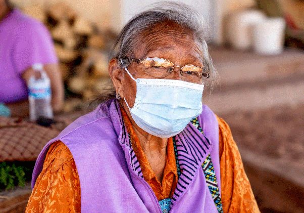 Elderly indigenous woman wearing surgical mask