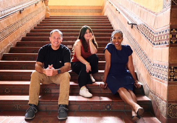 Benjamin Lewis, Daniela Cortez Bravo and Angela Deaver Campbell sitting together on the steps 