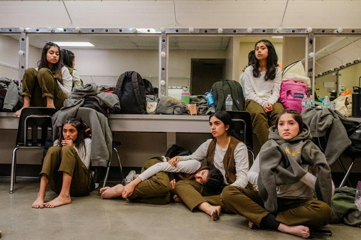 Members of the UCLA student dance team Nashaa rest backstage in a dressing room.