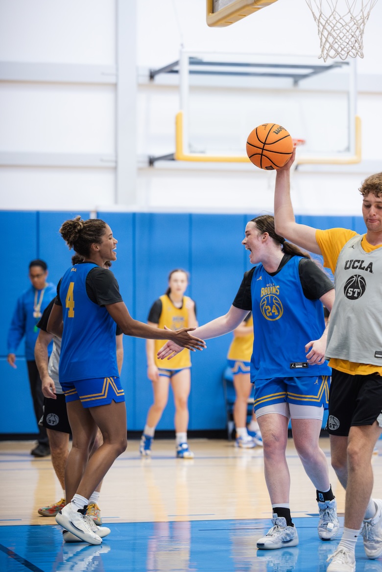 UCLA forward Addy Brown, wearing No. 24, exchanges a high-five with a teammate during preseason practice.