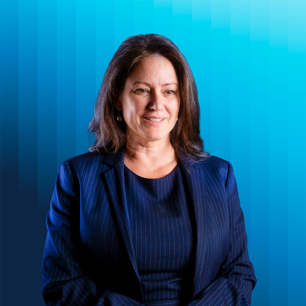  Portrait of Martha Bailey in dark blue pinstripe top and jacket against a blue background.