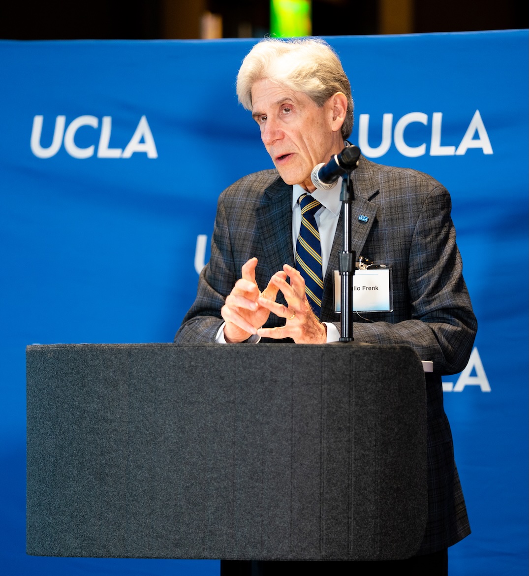 UCLA Chancellor Julio Frenk speaks and gestures with his hands behind a lectern and microphone, in front of a blue UCLA backdrop at the 2026 Andrea L. Rich Night to Honor Teaching.