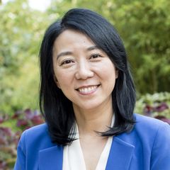Headshot of Yifang Zhu wearing a blue blazer, photographed outdoors.