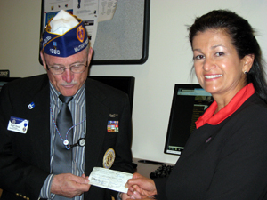 Roger D. Newall, Commander of the Dept. of New Mexico Military Order of the Purple Heart presents UNM Veteran's Resource Center Director Mandy Dykman with a check.