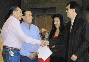 Isleta Pueblo representatives Daniel Waseta (l.) and Valentino Jaramillo shake hands with UNM Regents Carolyn Abeita and Jack Fortner after the vote on the land transfer.