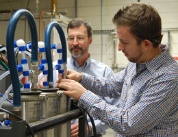 Kyle Hammond connects fittings on a reverse osmosis system that will be used to produce water for corrosion experiments.