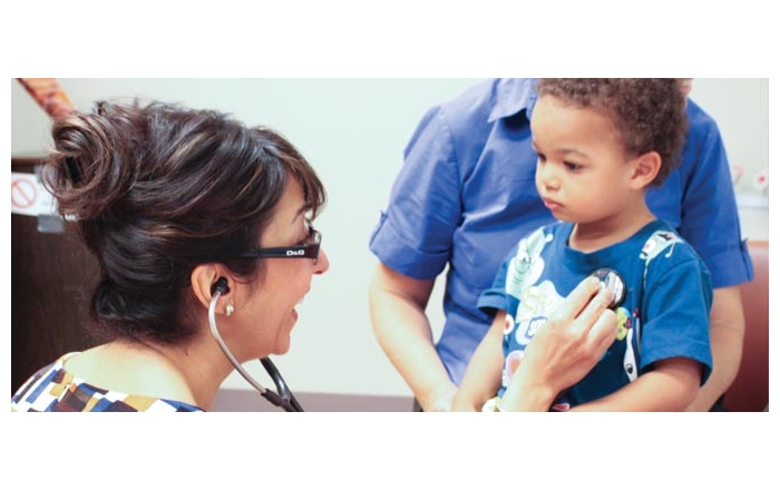 Hengameh Raissy, PharmD, listens to a young patient's lungs