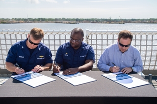 With the signing of the ceremonial documents, custody of the National Security Cutter Midgett (WMSL 757) is officially transferred to the U.S. Coast Guard. Pictured (left to right): Cmdr. Brian Smicklas, executive officer, Midgett (WMSL 757); Capt. Travis Carter, commanding officer, Project Resident Office Gulf Coast; and Derek Murphy, Ingalls’ NSC program manager. Photo by Derek Fountain/HII National Security Cutter Midgett (WMSL 757) Delivered