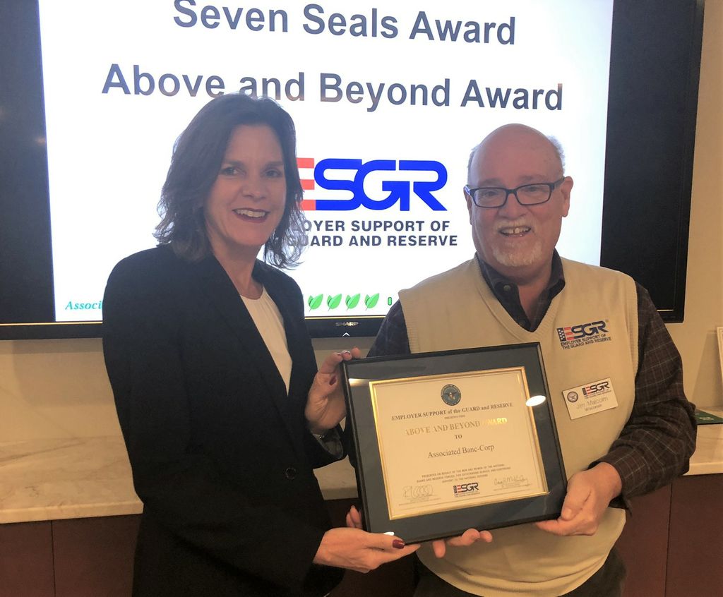 Angie DeWitt (left) accepts the awards on behalf of Associated Bank.