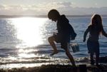 little kids play in sand at beach copy