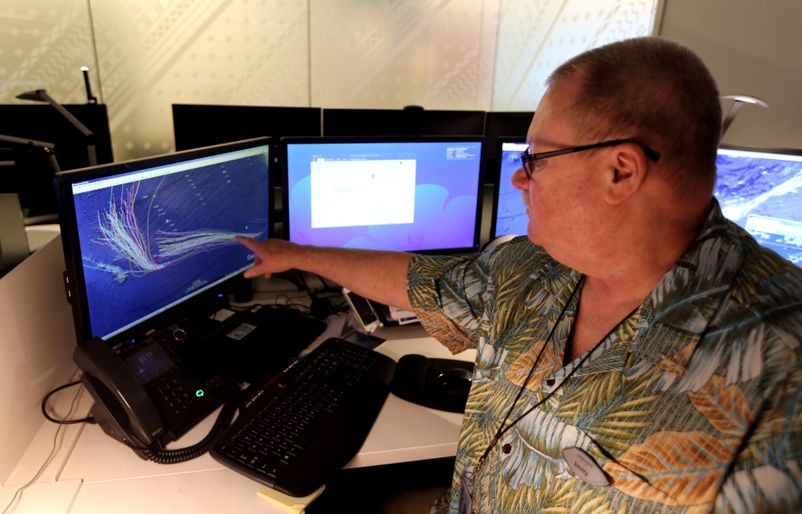 Kenneth Smith, senior director of dispatch at Hawaiian Airlines, points to one of the computer tools his team uses to track weather-related events. IMG_8201