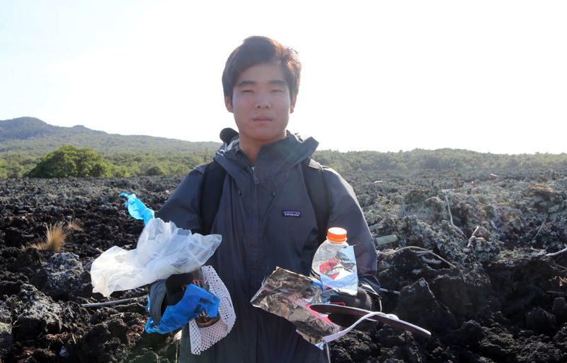 Brennan holds up a sample of trash he collected at the start of the Rangitoto cleanup initiative. Brennan