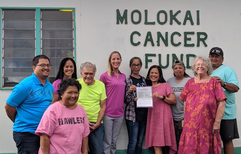 ‘Ohana By Hawaiian Managing Director Alanna James, pictured center in purple, and the Moloka‘i Cancer Center team gathering in celebration of the recent donation. MCF Donation 1